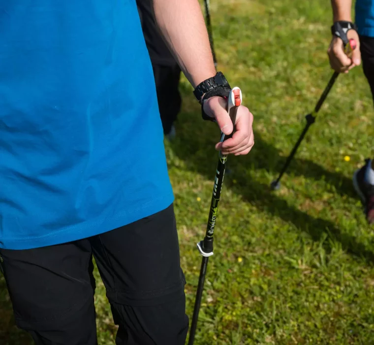 Detailaufnahme eines Nordic-Walking-Trainings im Bärenhof Bad Gastein – Gäste starten aktiv in den Tag mit professioneller Begleitung im Grünen.