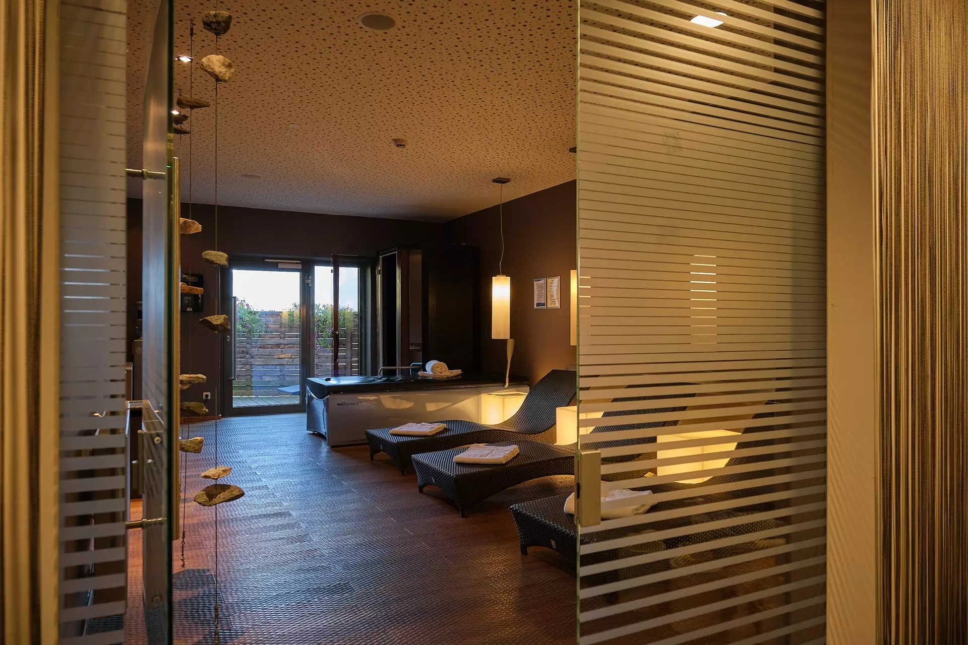 Entspannungsraum im Gesundheitszentrum Bärenhof Bad Gastein mit Liegen, Handtüchern und gedämpfter Beleuchtung für